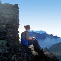 hiker writing her name on the guestbook at the top of Himmeltindan hiker writing her name on the guestbook at the top of Himmeltindan