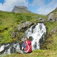 Hiker resting in front of a brook Hiker resting in front of a brook